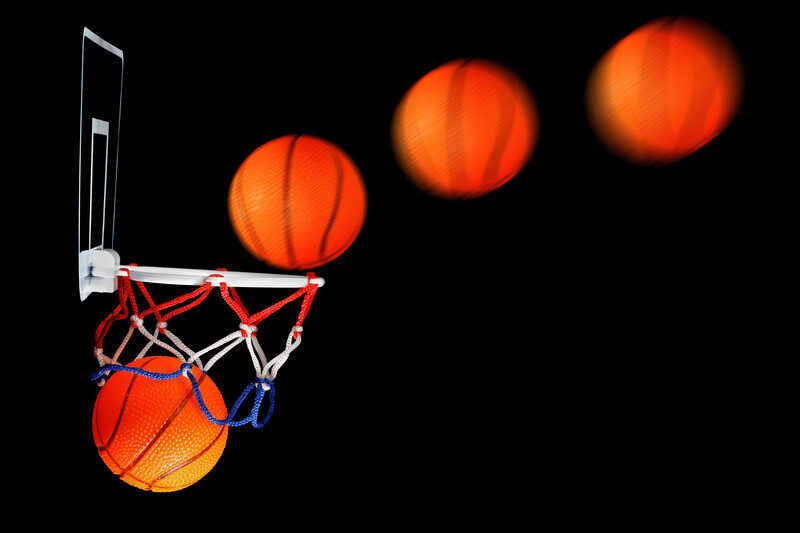 Phases of basketball going through the hoop isolated on black