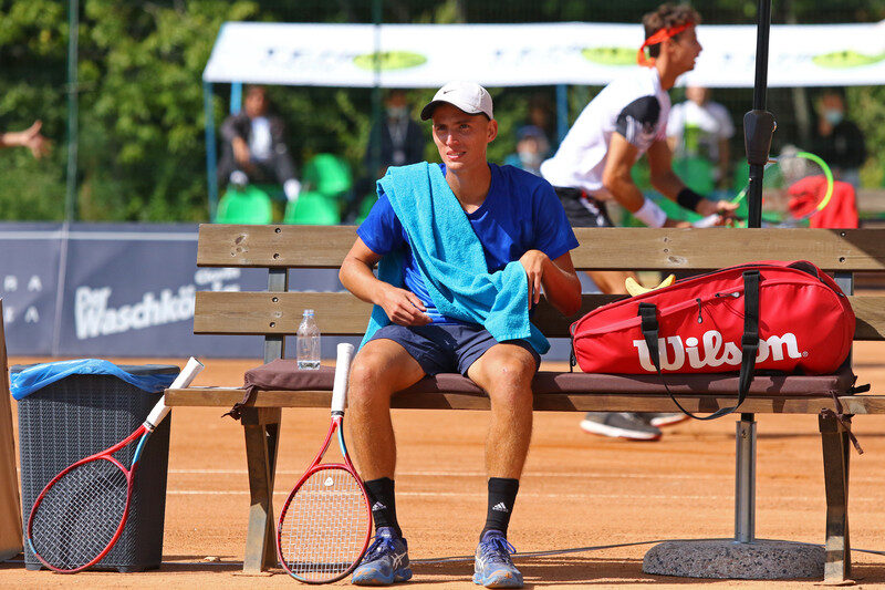 Tennis player in between points on a bench